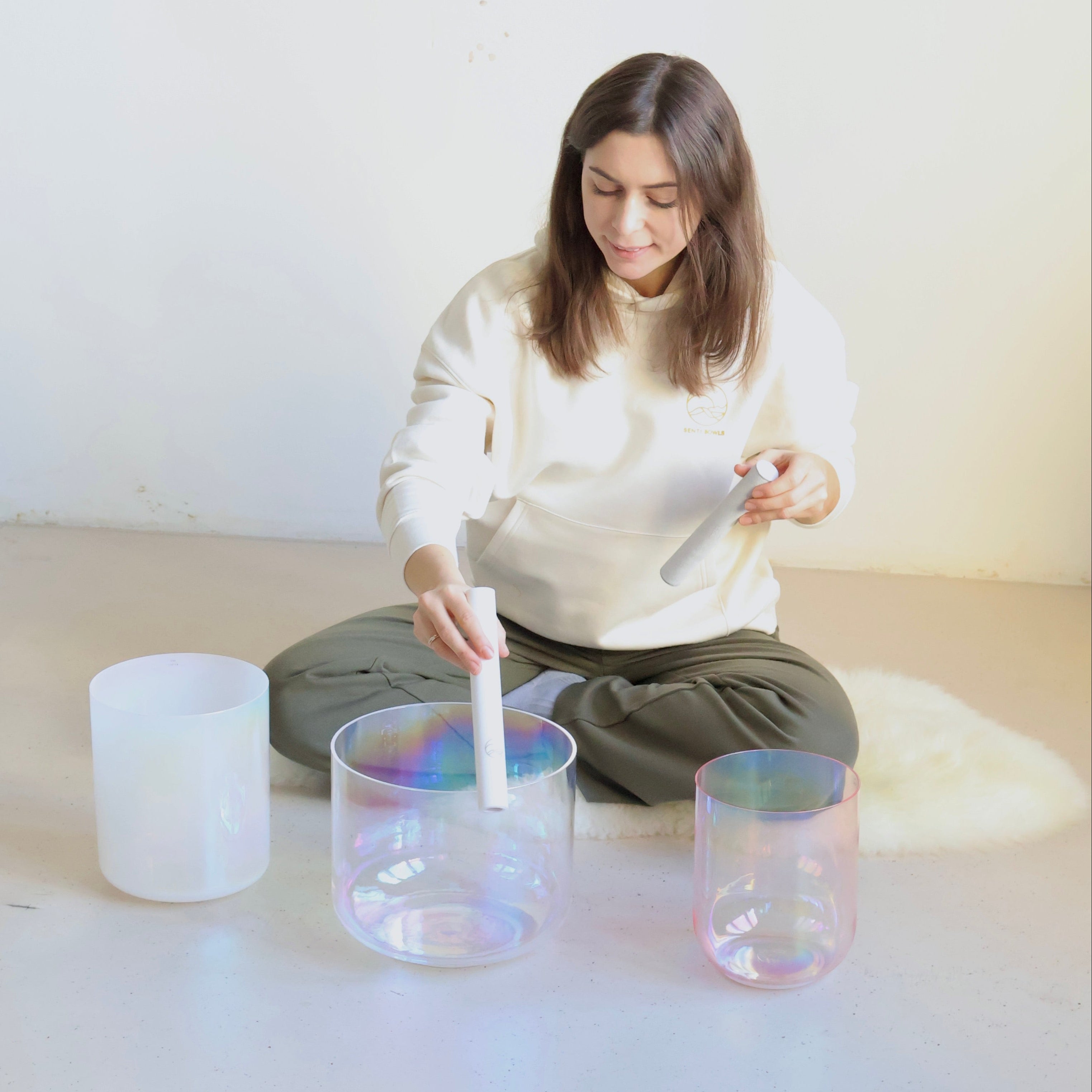 Lea, Senti Sound Practitioner, spielt eine handgefertigte Senti Bowls Kristallklangschale aus Quarzkristall, deren Klang Körper und Geist entspannt.
