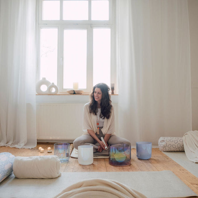 Moni, Senti Sound Practitioner, spielt eine handgefertigte Senti Bowls Kristallklangschale aus Quarzkristall, deren Klang Körper und Geist entspannt.